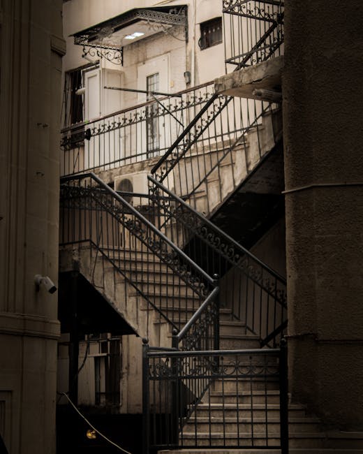 A narrow, indoor staircase with six wooden steps leading upward, enclosed by wooden framing and walls. The stairs are uncarpeted, showing visible wear and darkened edges. To the left of the staircase,